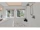 Elegant shower with marble walls, accent tiles, and natural light from nearby windows at 7570 Windford, Parker, CO 80134