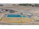 Community aerial shot showcasing tennis courts, pool, and playground amidst a scenic landscape at 17969 Sky Pilot Ave, Parker, CO 80134