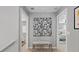 Hallway with neutral walls, bench, and decorative art leads to bedrooms on either side at 17969 Sky Pilot Ave, Parker, CO 80134