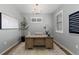 Bright home office with a modern light fixture, decorative rug, and natural wood desk for a productive workspace at 17969 Sky Pilot Ave, Parker, CO 80134