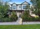 Charming two-story home with a landscaped yard, black iron fence, and inviting front porch at 8056 E 35Th Ave, Denver, CO 80238