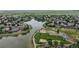 Aerial view of neighborhood with a pond and a community park with playground, all surrounded by green spaces at 7597 Bison Ct, Littleton, CO 80125