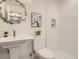 Clean and modern bathroom featuring a pedestal sink, toilet, and tiled shower area at 3961 S Clermont St, Cherry Hills Village, CO 80113