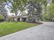 An exterior view of the home with a spacious front yard and long driveway leading to a garage at 3961 S Clermont St, Cherry Hills Village, CO 80113