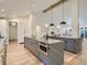 Spacious kitchen featuring a gray island with seating, built-in oven, and modern cabinetry at 3961 S Clermont St, Cherry Hills Village, CO 80113