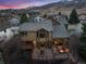 Aerial view showcases the home's expansive deck, outdoor seating, fire pit, and mountain backdrop at 34 Amaranth Dr, Littleton, CO 80127