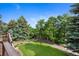 Secluded backyard with a well-manicured lawn, mature trees, and a fence, providing privacy and a park-like setting at 34 Amaranth Dr, Littleton, CO 80127