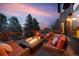 Relax on this deck with a cozy fire pit and comfortable patio seating with a lovely twilight sky at 34 Amaranth Dr, Littleton, CO 80127