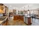 Open concept kitchen with wooden cabinets, stainless appliances, and stone tile flooring at 34 Amaranth Dr, Littleton, CO 80127