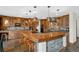 Luxurious kitchen with wooden cabinets, bar seating, pendant lighting, and a tile floor at 34 Amaranth Dr, Littleton, CO 80127