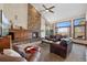 Inviting living room features a stone fireplace, vaulted ceilings, and scenic views from large windows at 34 Amaranth Dr, Littleton, CO 80127