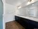 Bathroom showcasing a double sink vanity with granite countertop and dark cabinets at 1826 Sunshine Ave, Longmont, CO 80504