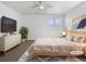 Cozy bedroom featuring soft decor, a ceiling fan, two windows and a dresser with TV at 1826 Sunshine Ave, Longmont, CO 80504