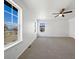 Spacious bedroom featuring carpet flooring, a ceiling fan, three windows, and neutral paint at 1826 Sunshine Ave, Longmont, CO 80504