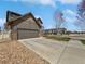 Spacious driveway leading to an attached garage, complemented by mature landscaping at 1826 Sunshine Ave, Longmont, CO 80504