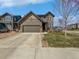 Charming two-story home with a two-car garage, landscaped yard, and neutral brown siding at 1826 Sunshine Ave, Longmont, CO 80504
