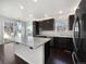 Bright kitchen featuring a large island, stainless steel appliances, dark cabinets, and sliding glass door at 1826 Sunshine Ave, Longmont, CO 80504