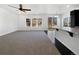 Open concept living room with a ceiling fan, large windows and sliding glass doors for natural light at 1826 Sunshine Ave, Longmont, CO 80504