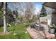 A landscaped backyard with an outdoor kitchen, lounge area, hot tub, and a sports net at 121 N Marion St, Denver, CO 80218