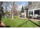 Landscaped backyard featuring an artificial lawn, an outdoor seating area, and mature trees at 121 N Marion St, Denver, CO 80218