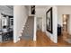 Hallway featuring wood floors, a staircase with runner, and views into the living and entertaining spaces at 121 N Marion St, Denver, CO 80218