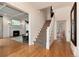 View of the foyer with wood floors, a staircase with patterned runner and an open doorway to the living room at 121 N Marion St, Denver, CO 80218
