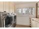 Functional laundry room with modern washer and dryer, ample cabinetry, and natural light at 121 N Marion St, Denver, CO 80218