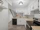 Bright kitchen featuring white cabinetry, modern appliances, and views to a staircase at 2909 W 81St Ave # E, Westminster, CO 80031