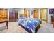 Spacious bedroom featuring a colorful quilt on the bed, wood doors, and neutral carpeting at 551 Rio Rancho Way, Brighton, CO 80601