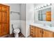 Cozy bathroom with toilet, sink and vanity, wood door, and wainscotting at 764 Blue Ridge Rd, Breckenridge, CO 80424
