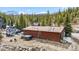 Rear exterior of charming log cabin with hot tub, patio furniture and scenic views of mountains and evergreens at 764 Blue Ridge Rd, Breckenridge, CO 80424