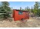 A red storage shed with wood stacked next to it is located in the backyard at 764 Blue Ridge Rd, Breckenridge, CO 80424