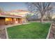 An expansive backyard, featuring lush green grass, a charming brick patio, and exterior access at 4550 S Fox St, Englewood, CO 80110