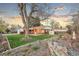 Large green yard with lovely landscaping features a tree, rock wall and grass that flows to the back patio at 4550 S Fox St, Englewood, CO 80110