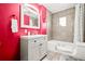 Well-lit bathroom with a shower-tub combo, tiled walls, and bright pink walls at 4550 S Fox St, Englewood, CO 80110