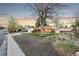 Quaint home at dusk with a large tree, fenced yard, and the curb appeal of mature trees and grass at 4550 S Fox St, Englewood, CO 80110