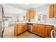Kitchen boasts stainless steel appliances, warm wood cabinets, and bright windows at 4550 S Fox St, Englewood, CO 80110