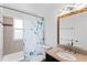 Bathroom with vanity and shower-tub combo with decorative mirror and sink and shower curtain at 5199 Arbutus St, Arvada, CO 80002