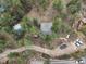 Aerial view of a charming home nestled among tall trees with ample parking at 4786 Forest Hill Rd, Evergreen, CO 80439