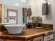 Comfortable bathroom featuring stone countertops with a vessel sink, decorative mirror, and soft natural light at 4786 Forest Hill Rd, Evergreen, CO 80439