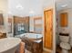 A luxurious bathroom boasts an oversized soaking tub, a standing shower, and earth-toned stone tiling at 4786 Forest Hill Rd, Evergreen, CO 80439