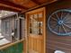 Charming front entrance featuring a rustic wooden door and wagon wheel accent at 4786 Forest Hill Rd, Evergreen, CO 80439