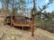 Wood cabin featuring an expansive wooden deck overlooking a sloped yard among the trees at 4786 Forest Hill Rd, Evergreen, CO 80439