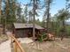 Charming cabin nestled among towering trees with a spacious deck for outdoor enjoyment at 4786 Forest Hill Rd, Evergreen, CO 80439