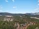 Breathtaking view showcasing mountains in the distance, seen through trees on a sunny day at 4786 Forest Hill Rd, Evergreen, CO 80439