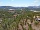 Expansive mountain range view showcasing the property's serene setting among lush greenery at 4786 Forest Hill Rd, Evergreen, CO 80439