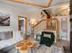 Cozy living room featuring wood beams, a staircase, and an open doorway leading to a closet with ample storage at 4786 Forest Hill Rd, Evergreen, CO 80439