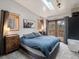 Comfortable main bedroom with a king bed, skylight, windows, access to a deck, and stylish decor at 4786 Forest Hill Rd, Evergreen, CO 80439