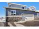 Gray exterior with attached garage and stone accents at 15501 E 112Th Ave # 3F, Commerce City, CO 80022