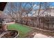 Backyard showing artificial turf, flower beds, and wrought iron fence at 5311 S Danube Ct, Centennial, CO 80015